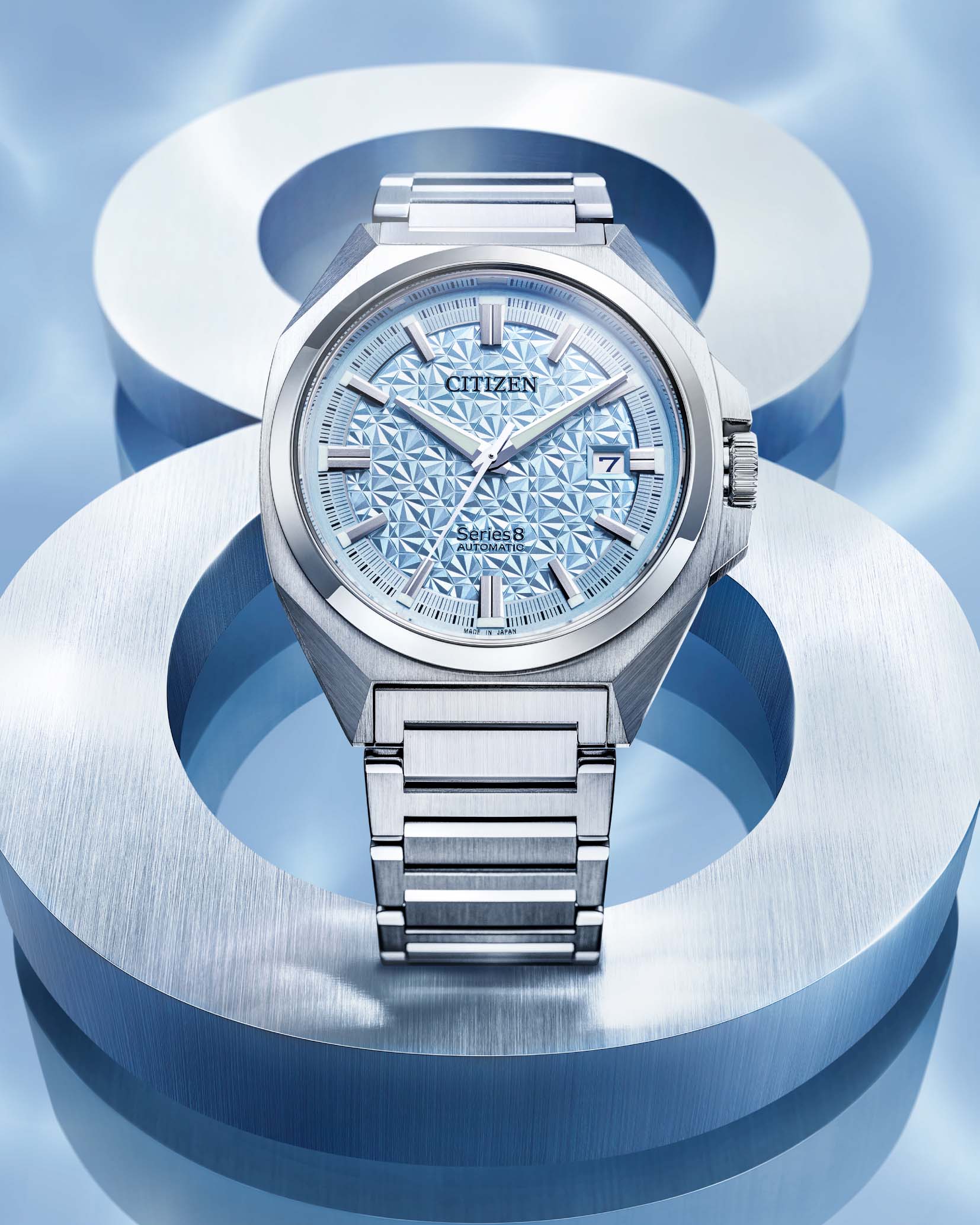 A steel watch with a blue face on a blue background