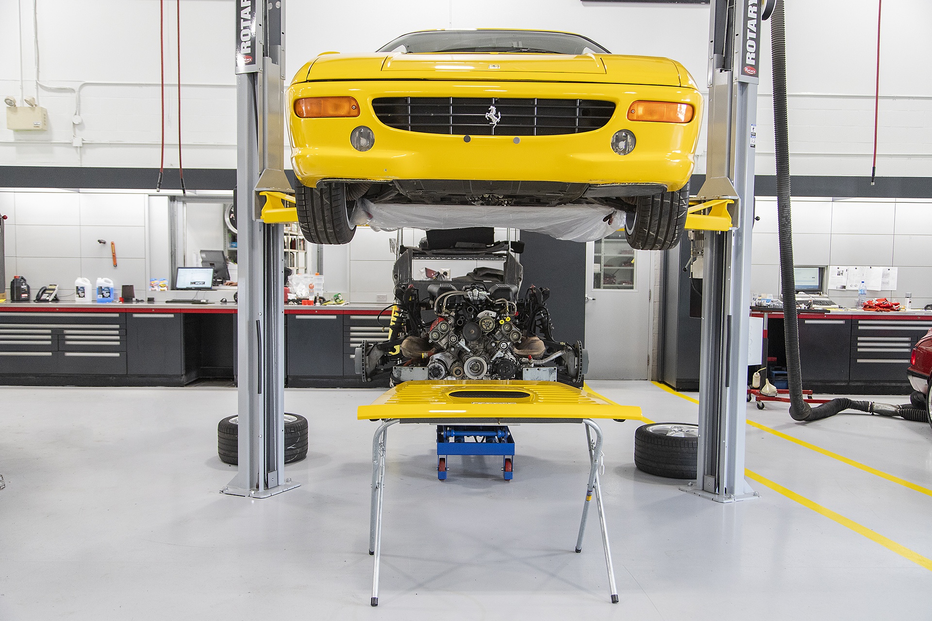 Yellow Ferrari sports car in garage being repaired